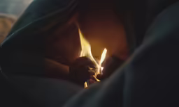 someone with a lit match lighter in their hand