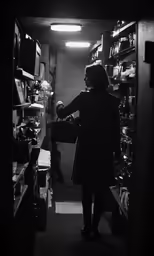 an older woman looks out into a store with no door