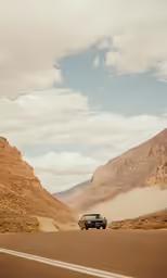 a car drives on a road in the desert