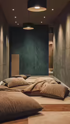 two beds on the floor of a room with brown pillows