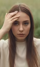 a woman is sitting in front of a field