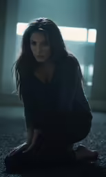 the young woman is sitting on a rug in a dark room