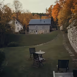 two lawn chairs and one table outside on the lawn