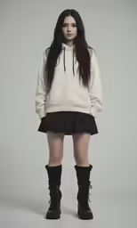 a girl with long hair is standing in front of a gray background