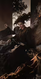woman in vintage dress sitting on bed in darkened room