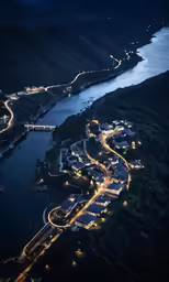 an aerial photo of a night town near a large river