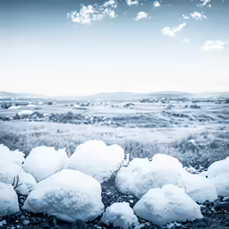 a field of snow covered rocks on a clear day