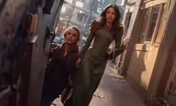 two women in dresses are walking down a city street