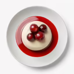 an up close photo of a small dessert with cherries