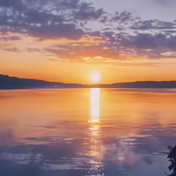 a lake with the sun rising over the horizon