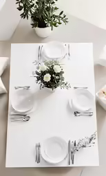 a table is decorated with flowers and white plates