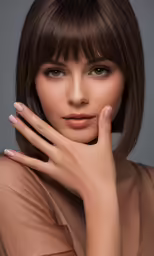 a beautiful woman in a nude dress with her hand on her cheek