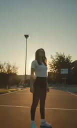 a girl posing in an outdoor basketball court