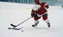 a man in red is playing a game of ice hockey