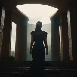 the woman in the black dress stands on steps