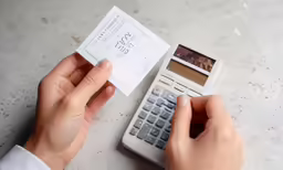 the person is using the calculator to insert a ticket