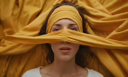 a woman with a yellow cloth draped around her head