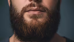 an image of a man with a beard looking into the camera