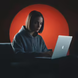 a person sitting on a couch looking at a laptop