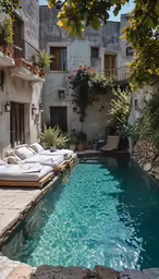 an outdoor pool with chaise lounges and pillows