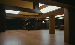 a person standing in an empty room with a guitar