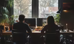 the couple is sitting at their computer in the dark