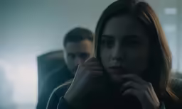 a young woman stares at a man on the train
