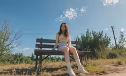 a girl sitting on a wooden bench looking at the sky