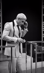 the man is dressed in a suit and tie talking on the phone