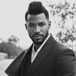 a young man with a goatee and suit jacket