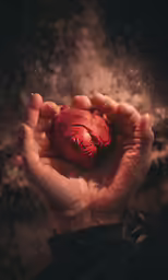 a person holding something red and shiny