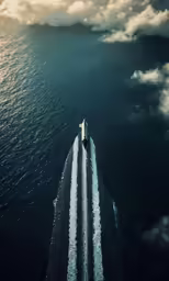 an aerial photo of a boat floating on the water