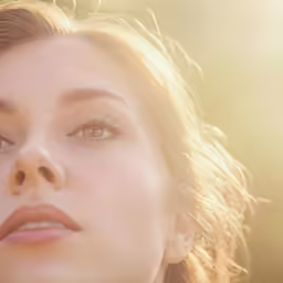 the woman is looking into the distance with a neutral light on her face