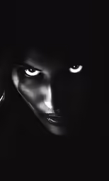 a black and white photo of a woman with her face illuminated