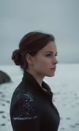 a woman with a ponytail is standing outside on the snow