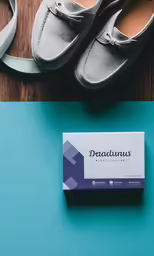 a pair of grey shoes and a business card
