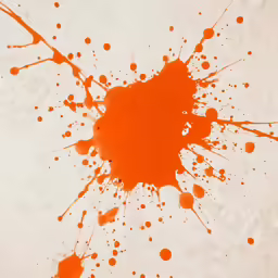 ink splattered in orange and white with a black dot on the left corner