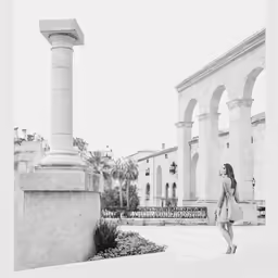 a woman is walking down the sidewalk next to some old buildings