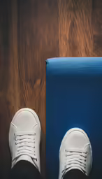 man standing on a yoga mat with his white sneakers