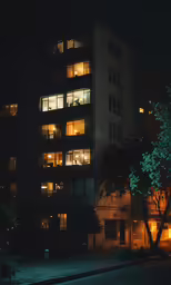 an image of a building at night with windows lit up