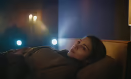 a woman in a tan jacket in the dark