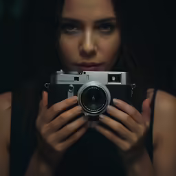 a woman holding a camera and taking a photo