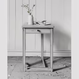 a vase with flowers sits on a wooden table