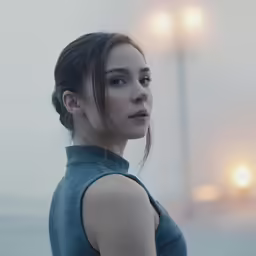 a girl stands at the side looking into the distance