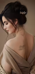 a woman in a brown gown with her arm tattoos