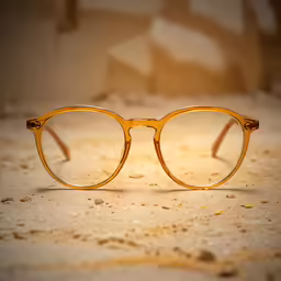a pair of glasses sitting on top of a sandy floor