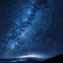 dark night sky over a mountain with stars