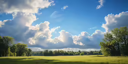 the sun shining through the clouds over a field