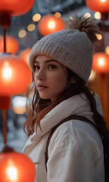 a woman standing in front of a wall with lanterns