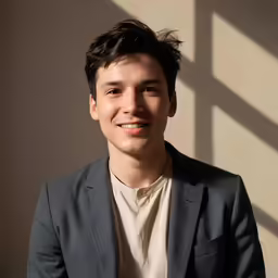 young man wearing a suit and smiling at the camera